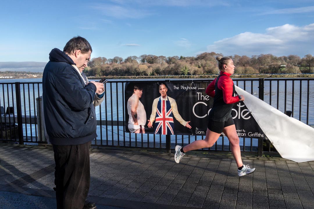 A woman jogs in front of a poster of the Playhouse Theater in Derry/Londonderry, Northern Ireland. JP/Okky Ardya