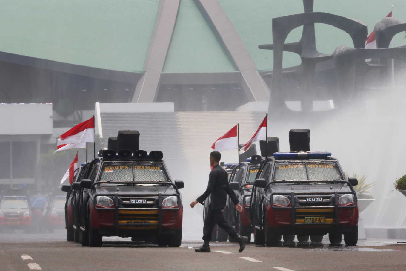 National Police personnel drive near Senayan Parliament Complex in Jakarta on Thursday. Up to 30,000 Indonesian Military (TNI) and police personnel were deployed to secure the inauguration of President Joko “Jokowi” Widodo and Vice President Ma’ruf Amin on Sunday. JP/Dhoni Setiawan