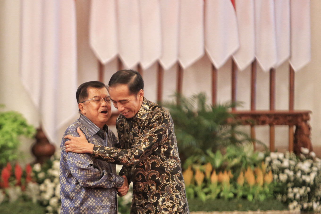 President Joko “Jokowi” Widodo and then-vice president Jusuf Kalla hug one another after a gathering with Cabinet members at Merdeka Palace in Jakarta on Friday. JP/Seto Wardhana