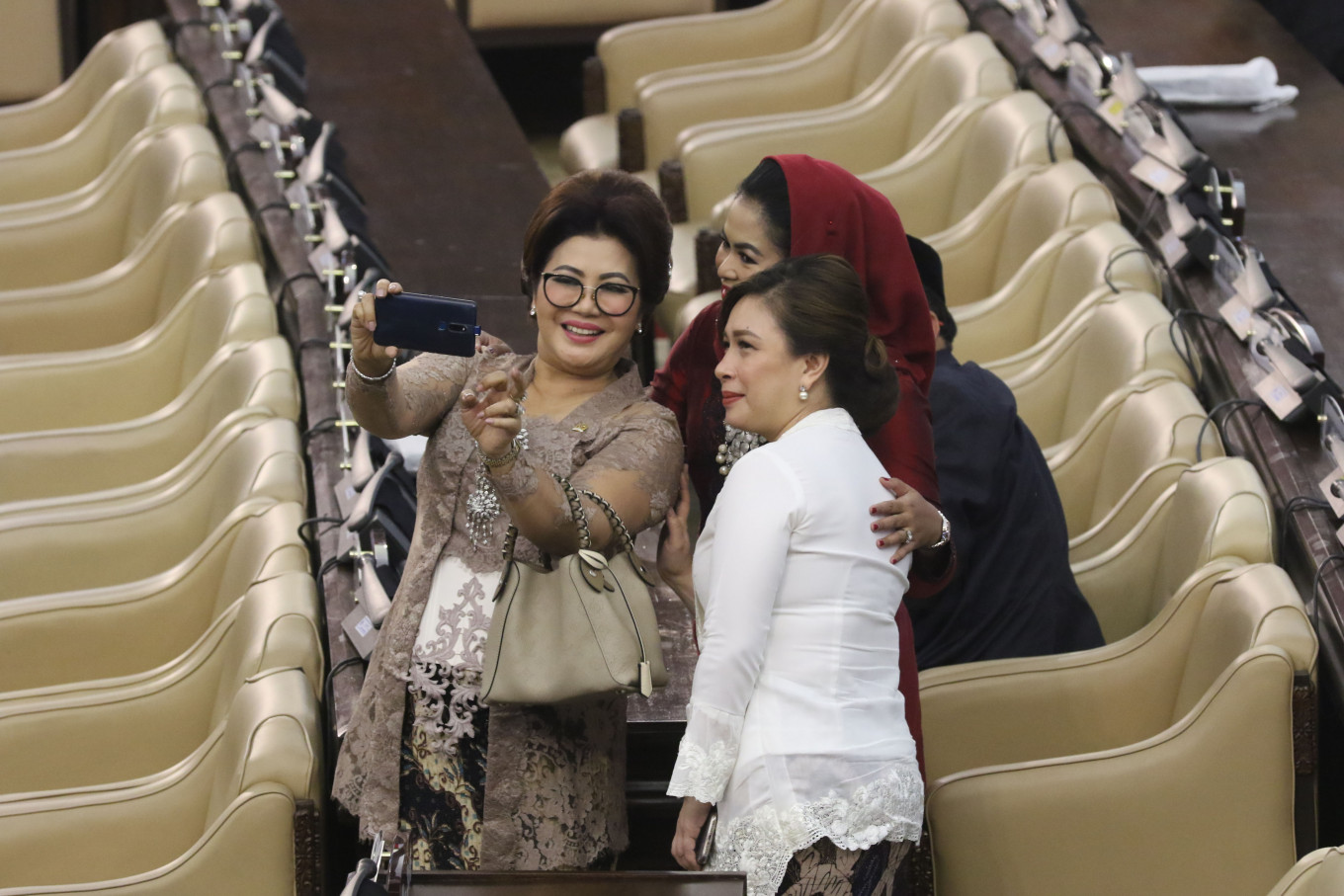 People's Consultative Assembly (MPR) members take selfies while waiting for the inauguration ceremony of President Joko “Jokowi” Widodo and Vice President Ma'ruf Amin at the Plenary Meeting Room of the Parliament Complex, Senayan, Jakarta, on Sunday. JP/Dhoni Setiawan