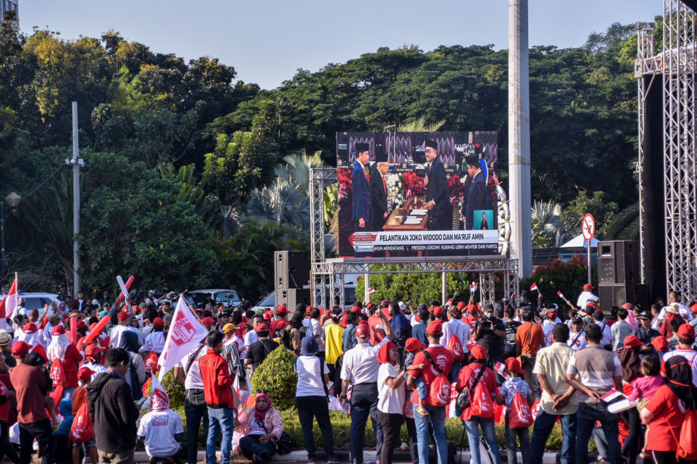 Supporters of Joko “Jokowi” Widodo and Ma’ruf Amin gather to watch the pair be inaugurated as the country’s president and vice president on a big screen near the Patung Kuda (Horse Statues) landmark on Jl. Medan Merdeka Barat in Central Jakarta on Sunday, Oct. 20. JP/Anggie Angela