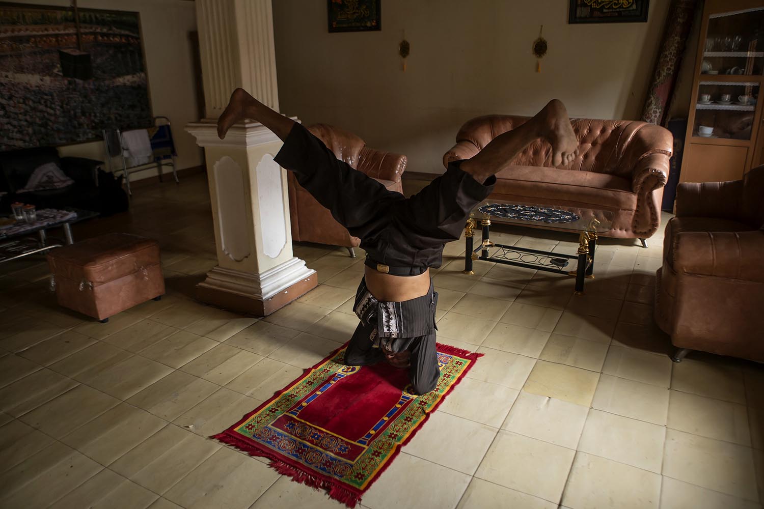 Practicing silat on sajadah (prayer mat) is considered an exercise to improve one’s strength and balance. JP/Ramadhani
