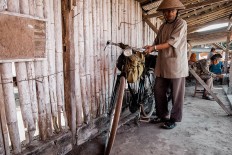 Suhardi gets ready to cycle home. JP/Anggertimur Lanang Tinarbuko