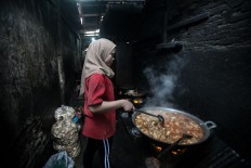 A restaurant staff member cooks food to be served at a Minang-style restaurant in Medan, North Sumatra. JP/Andri Ginting