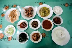 Nasi Padang is spread out on the dining table, comprising steamed rice, beef, chicken and fish dishes, as well as sambal and vegetables. JP/Andri Ginting