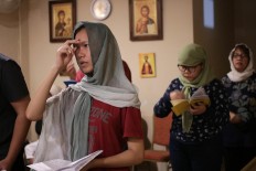 In the name of the father: Orthodox believers make the sign of cross before praying. Orthodox believers are a minority in Indonesia. JP/ Taufan Wijaya
