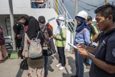 Ferry attendants check passengers' data prior to boarding the ferry. JP/Rosa Panggabean