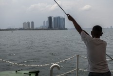A ferry passenger views Jakarta's skyscrapers. JP/Rosa Panggabean