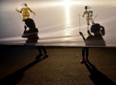 Shadows of plastic puppets appear on the screen. JP/ Aman Rochman