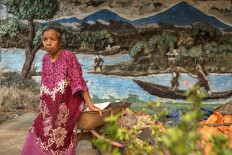 Jahri stands in front of her house in Siluluk, Dharmasraya. The diorama was carved in 1984 when the house was built, depicting the story of Jahri and her husband whose lives depended on the natural richness of the Batang Hari River. JP/Ramadhani