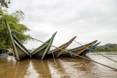 Traditional boats, tempek, are tied to a dock. Tempek were once the main mode of transportation on the river. They have become less popular now, but are still a favorite for some. JP/Ramadhani