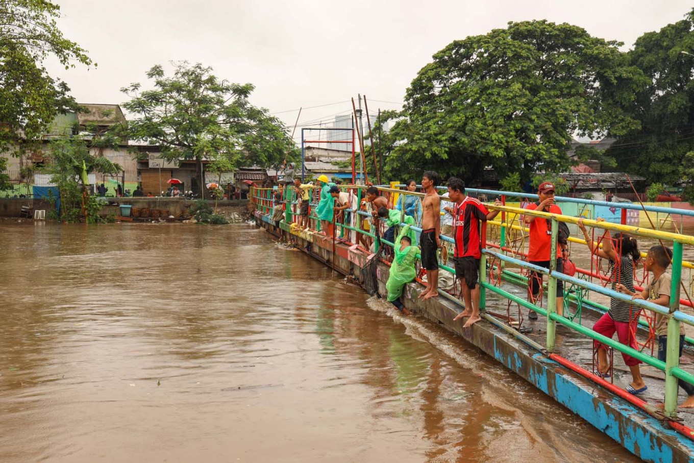 Different kind of fishing: Residents of Kota Bambu in West Jakarta take advantage of the Ciliwung River's high water levels to collect floating goods to use or sell.