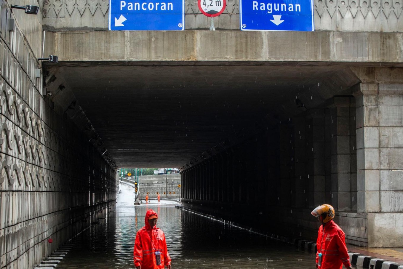 Sanitation workers clear away garbage from the Mampang-Kuningan underpass in Central Jakarta on Wednesday. Main thoroughfares and toll roads in the city were inundated after heavy rainfall in the first day of 2020.