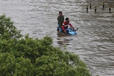 A motorcyclist rides through a flood on Jl. S. Parman in West Jakarta on Jan. 1. JP/Dhoni Setiawan