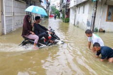 Children play during a flood in Pasar Baru, Central Jakarta, on Jan. 1. Antara/M Risyal Hidayat