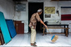 Rama Dwijo sweeps the outer area of the KHP Kridha Mardawa before the class starts. JP/Anggertimur Lanang Tinarbuko