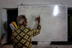 Rama Dwijo writes Javanese script on a whiteboard. JP/Anggertimur Lanang Tinarbuko