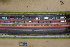 Get in line: Cars use an underpass as a flood inundates Jl. Angkasa in Central Jakarta on Thursday. Antara/Sigid Kurniawan