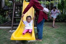 afitri Zaskia, 3, plays with her mother before her scheduled practice at Puspadi. Born in East Lombok, Safitri came to Bali to receive her first prosthetic legs with the help of the Lombok Disability Center and Endri’s Foundation. JP/Agung Parameswara
