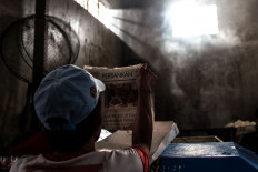 Juhro, an employee, reads a newspaper during a break from work. JP/Afriadi Hikmal
