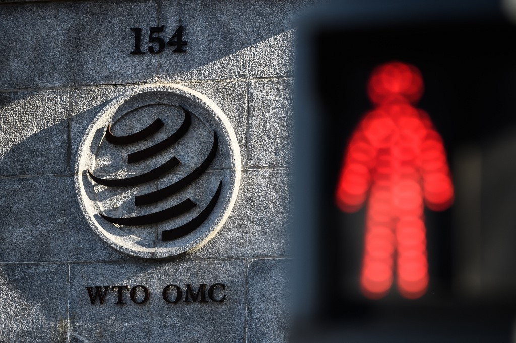 A red pedestrian trafic light is seen next to the entrance of the headquarters of the World Trade Organization (WTO) on Dec. 10, 2019 in Geneva. Global trade could plummet by a third this year due to the coronavirus pandemic, the World Trade Organization said Wednesday