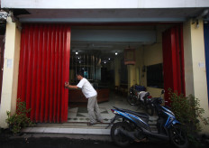 A man opens the door to a gold shop. JP/Boy T Harjanto