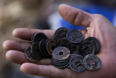 Blast from the past: Antique coins are held up by a treasure hunter. They are believed to have belonged to Chinese merchants and to have originated in Holland. JP/ Sigit Pamungkas