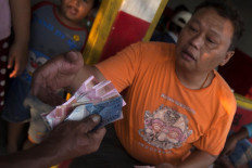 Good business: A trader pays a treasure hunter for valuable artifacts found on the riverbed. JP/ Sigit Pamungkas