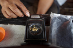 Gram by gram: A trader weighs gold fragments found by a treasure hunter. JP/ Sigit Pamungkas