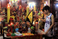 Aldo, the little brother of Ahen, burns an incense stick prior to the parade. JP/HS Putra