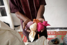 Sweet treats: A man holds sachets of sugar. The sachets’ different colors symbolize diversity. JP/Ramadhani