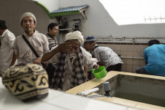 Wash first, pray later: Men perform their wudhu (ablutions) before a prayer at the Muhammadan Mosque in Padang, West Sumatra, on Jan. 25. Following the prayer, they took part in the Serak Gulo ceremony. JP/Ramadhani