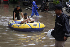 Pleasure cruise: A man takes a selfie as he is pushed in a rubber boat in an inundated part of Jl. Kemang Raya in South Jakarta on Tuesday. JP/Wendra Ajistyatama