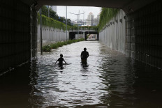 Urban river: Kids play under the inundated Kemayoran underpass in Gunung Sahari, Central Jakarta, on Tuesday. JP/Seto Wardhana