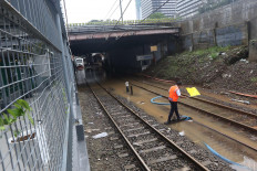 Sorry, we’re closed: A railway officer gives a signal using his flag on a flooded railway at Sudirman Station in Jakarta on Tuesday. JP/Dhoni Setiawan