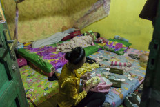 Puspita undoes her hair after finishing eight hours of wayang performance. She and her family comes home at 5 a.m. JP/Irene Barlian