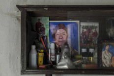A cupboard displays a photograph (center) of Puspita&rsquo;s celebrated father, Dalang Priyo Widodo. He is the one who first taught Puspita the traditional performing art of wayang.  JP/Irene Barlian