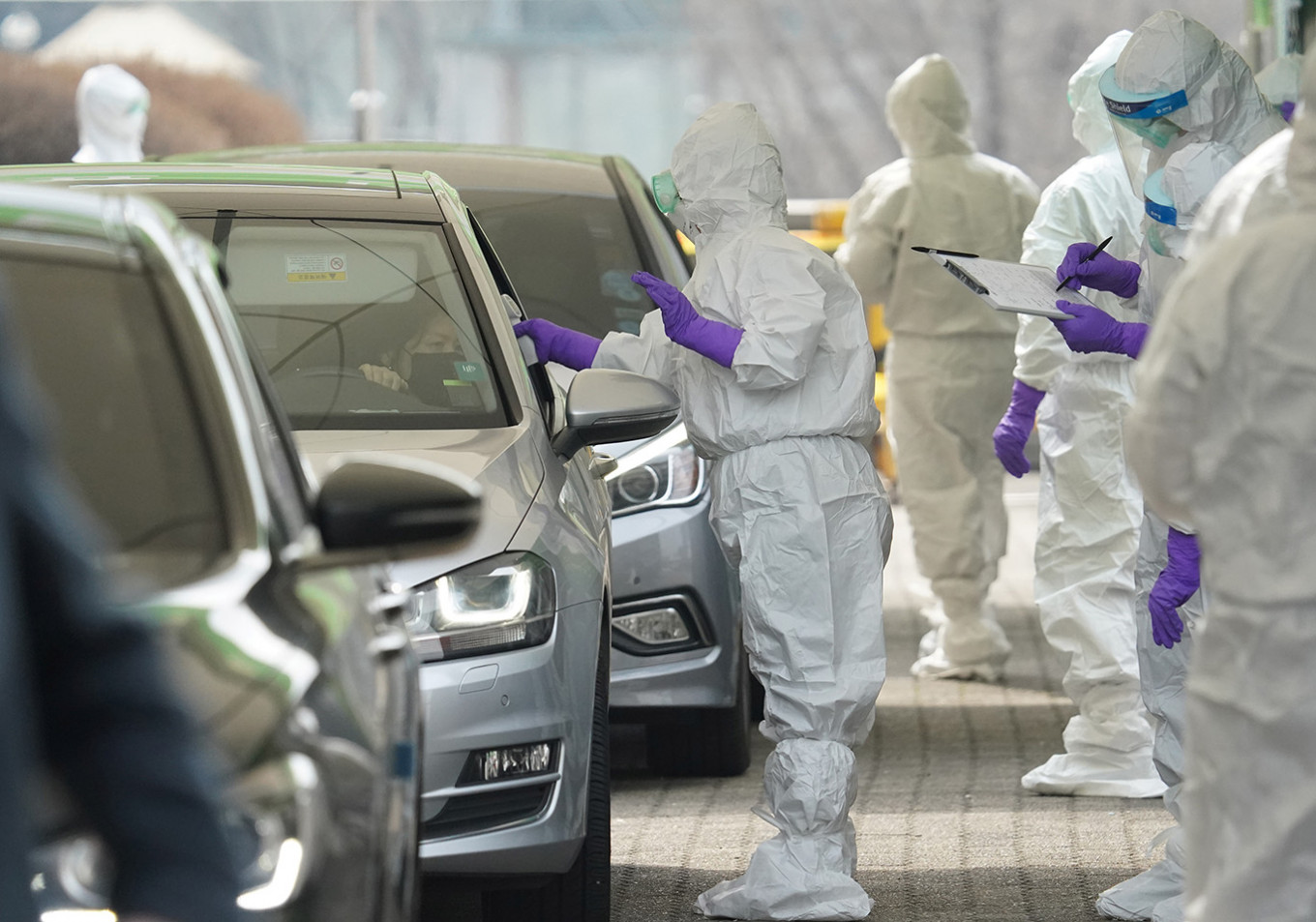 A driver gets a coronavirus test at a drive-through clinic in Seoul, South Korea, on Tuesday. Korea hasn’t put any curbs on internal movement in place, instead testing hundreds of thousands of people everywhere from clinics to drive-through stations.