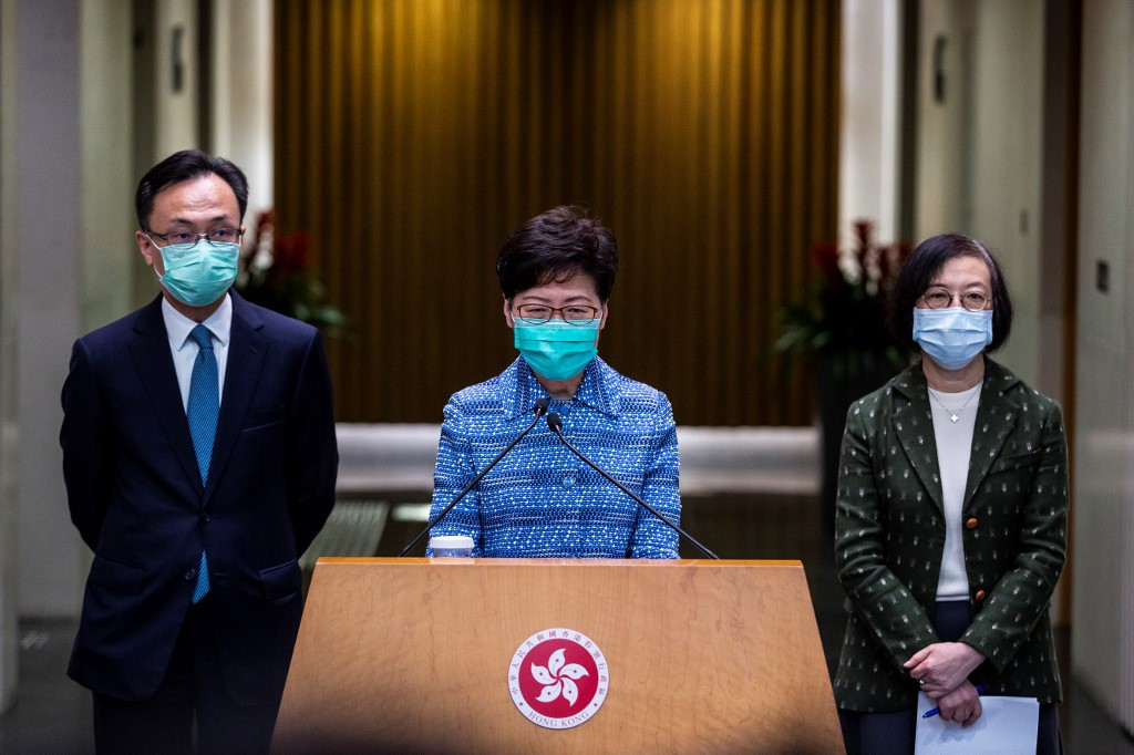 Hong Kong's Chief Executive Carrie Lam (C), Secretary for Constitutional and Mainland Affairs Patrick Nip (L) and Hong Kong's Secretary for Food and Health Sophia Chan (R) take part in a press conference while wearing face masks in Hong Kong on March 3, 2020. 