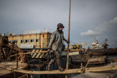 Job done: A worker carries his gloves from the worksite after finishing breaking up a ship. JP/Afriadi Hikmal