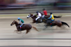In a flash: Jockeys ride at high speed while horse owners and spectators cheer from the stands. JP/Hotli Simanjuntak