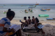 Children find a hand shade for reading their books at Mali Beach on Alor Island, East Nusa Tenggara. JP/ Yusuf Wahil