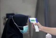 An employee gets her temperature checked. JP/Fauzan
