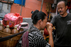 Handayani kisses her husband’s hand before she leaves home to sell jamu. The couple live with their children and grandchildren in Pesanggrahan. JP/Rahmat Dian Prasanto