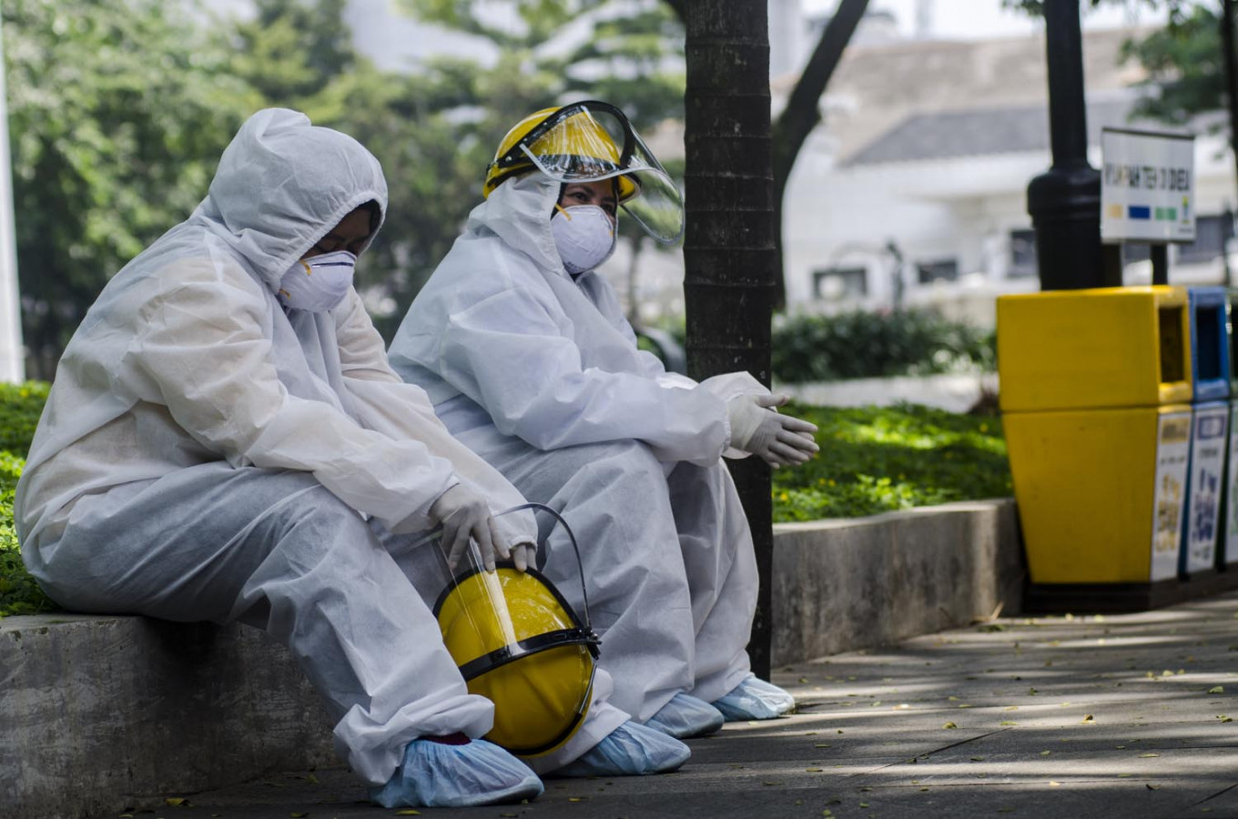 Medical workers take a break as rapid testing for COVID-19 is carried out at Bandung City Hall Park in Bandung, West Java, on Saturday. The tests were administered on 700 people. 