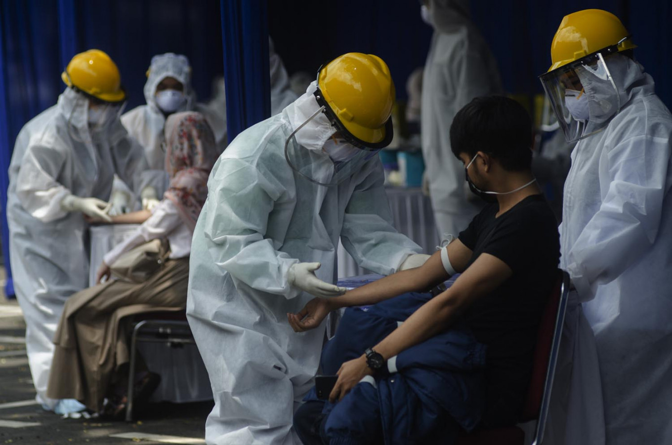 Medical workers take blood samples while conducting rapid tests for COVID-19 at Bandung City Hall Park in Bandung, West Java, on April 4.
