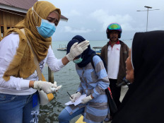 Local health staff record the identity of a woman who had just arrived on the island. JP/ Edy Susanto

