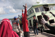 Passengers must have their temperature checked and their bodies and luggage sprayed with disinfectant before continuing their journey on the island.  JP/ Edy Susanto