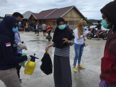 Health workers ask an arriving passenger to identify herself at Ambeua Port on Kaledupa Island. JP/ Edy Susanto
