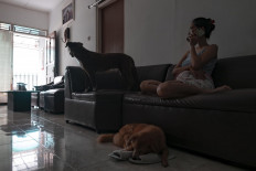 Astri Suryani, a manager at a private company, arranges the salary payments of employees through a phone call at her home in Yogyakarta on April 3. JP/Arnold Simanjuntak
